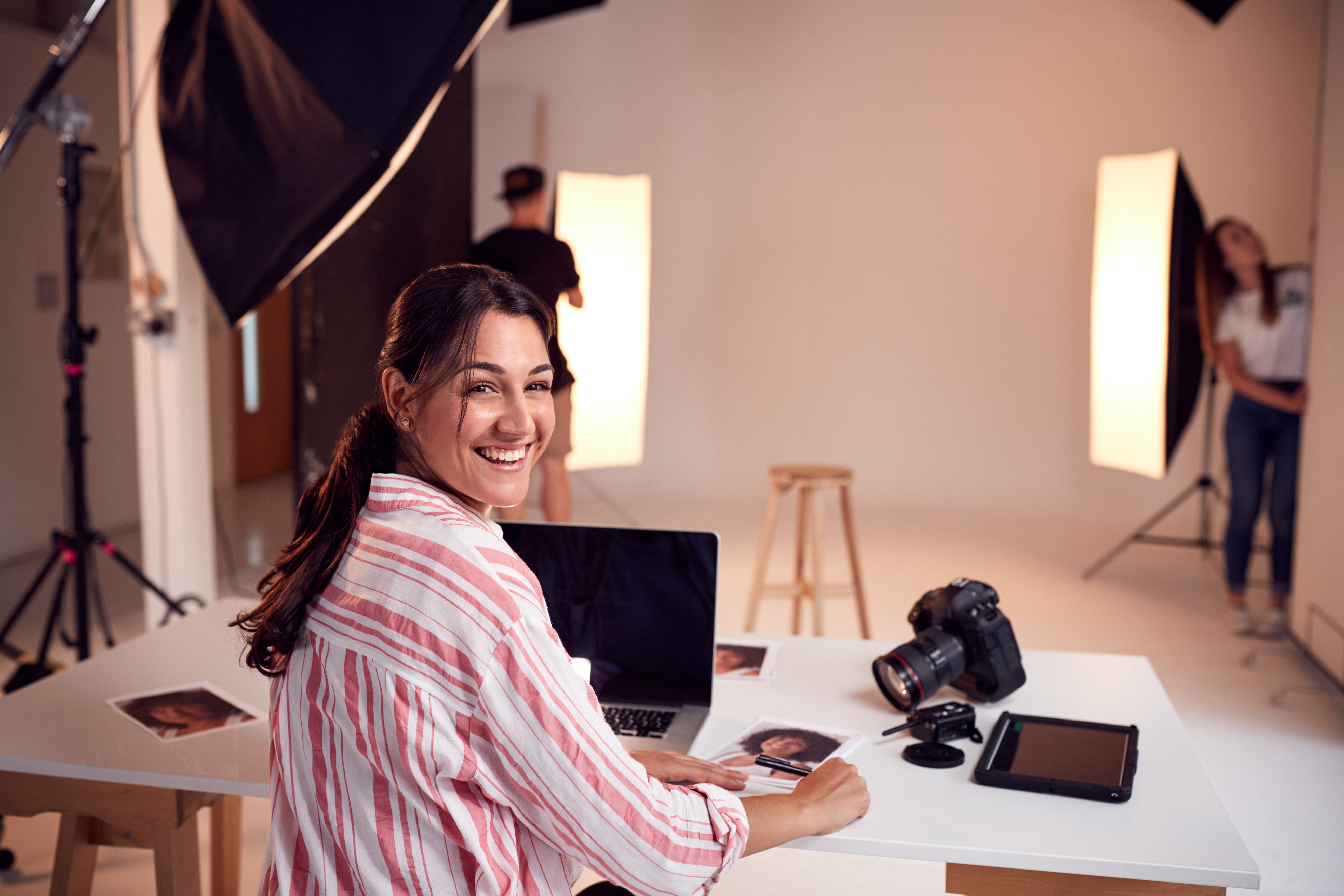 Professional Female Photographer Working In Studio With Assistants