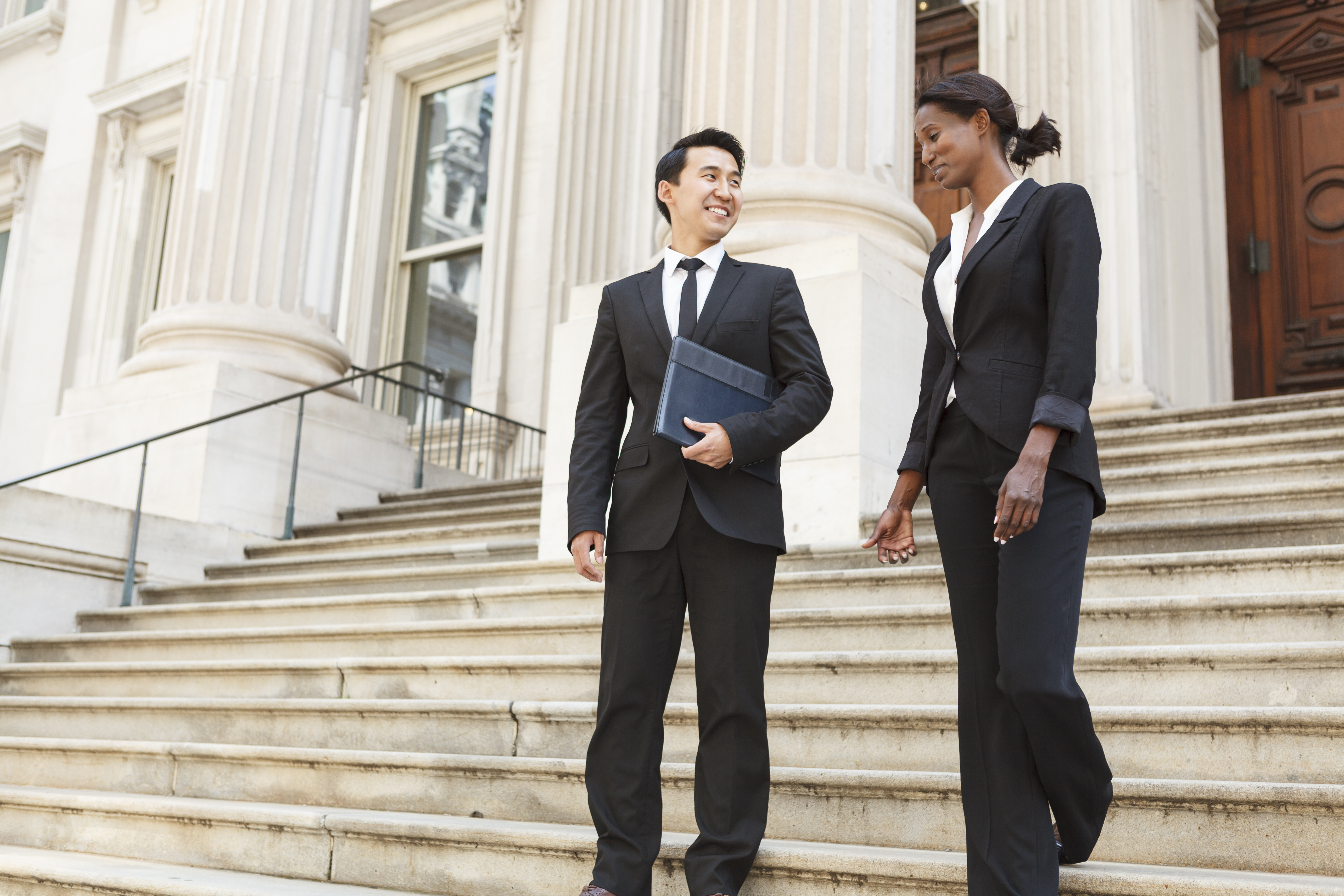 Two lawyers standing in front of a courthouse